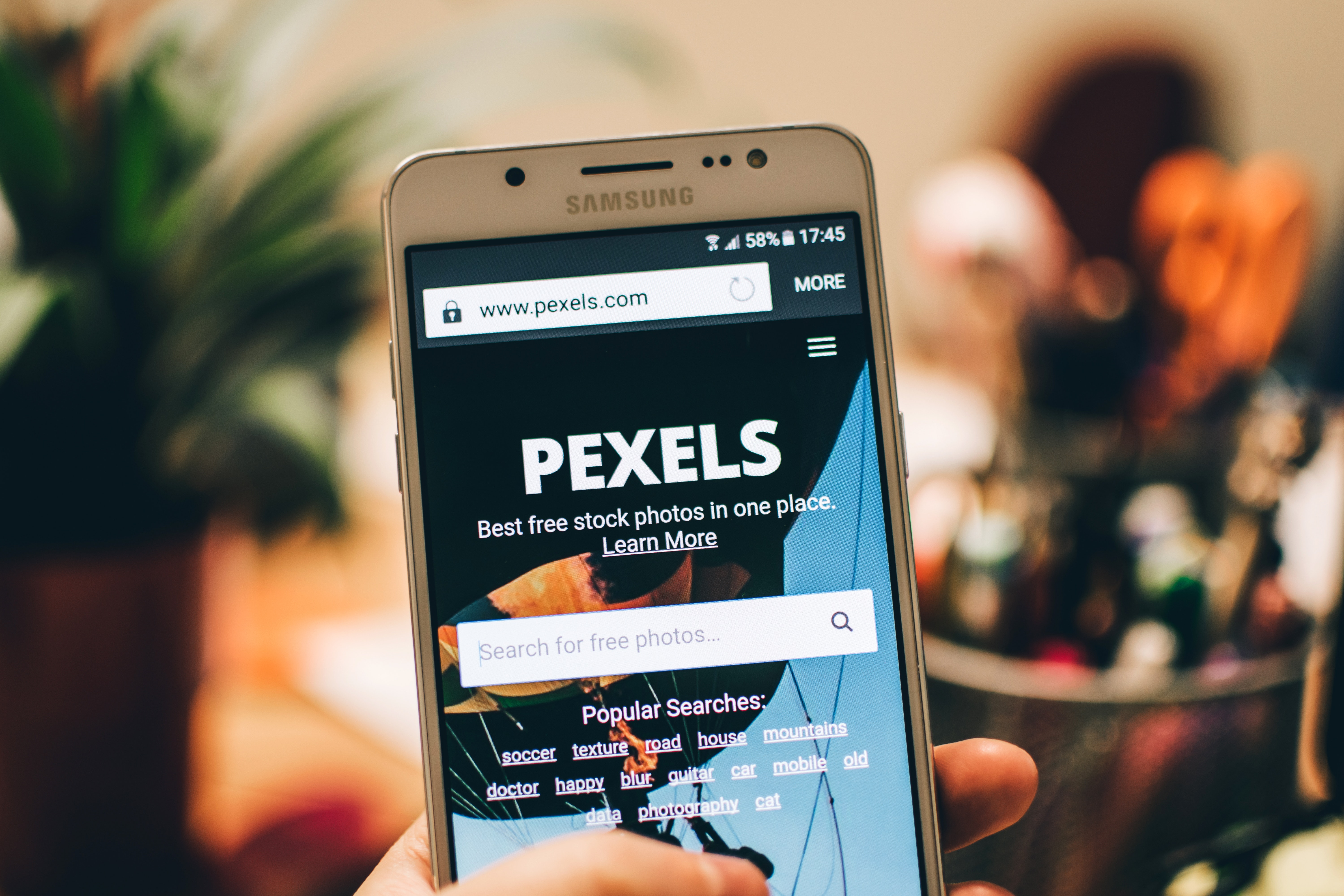 A person holding a smartphone with the pixells website on it.