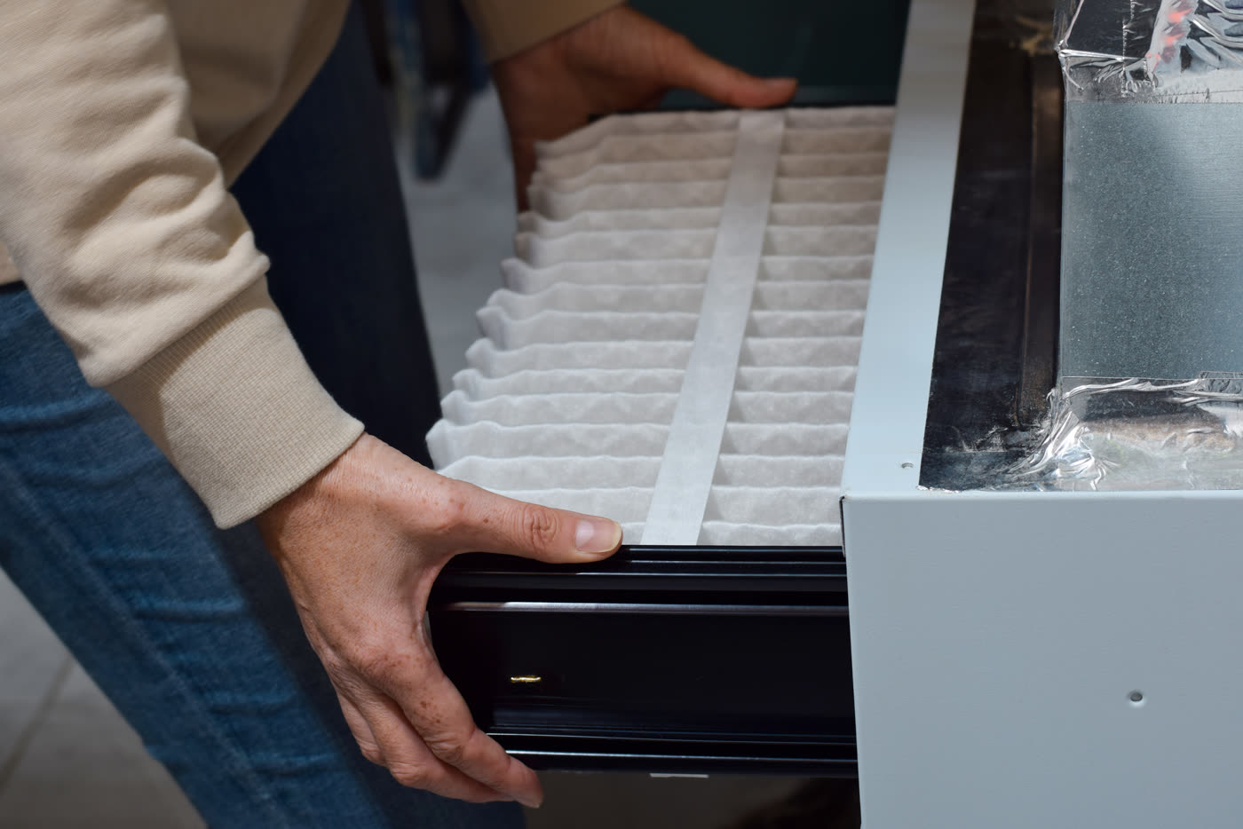 Hands installing an air filter